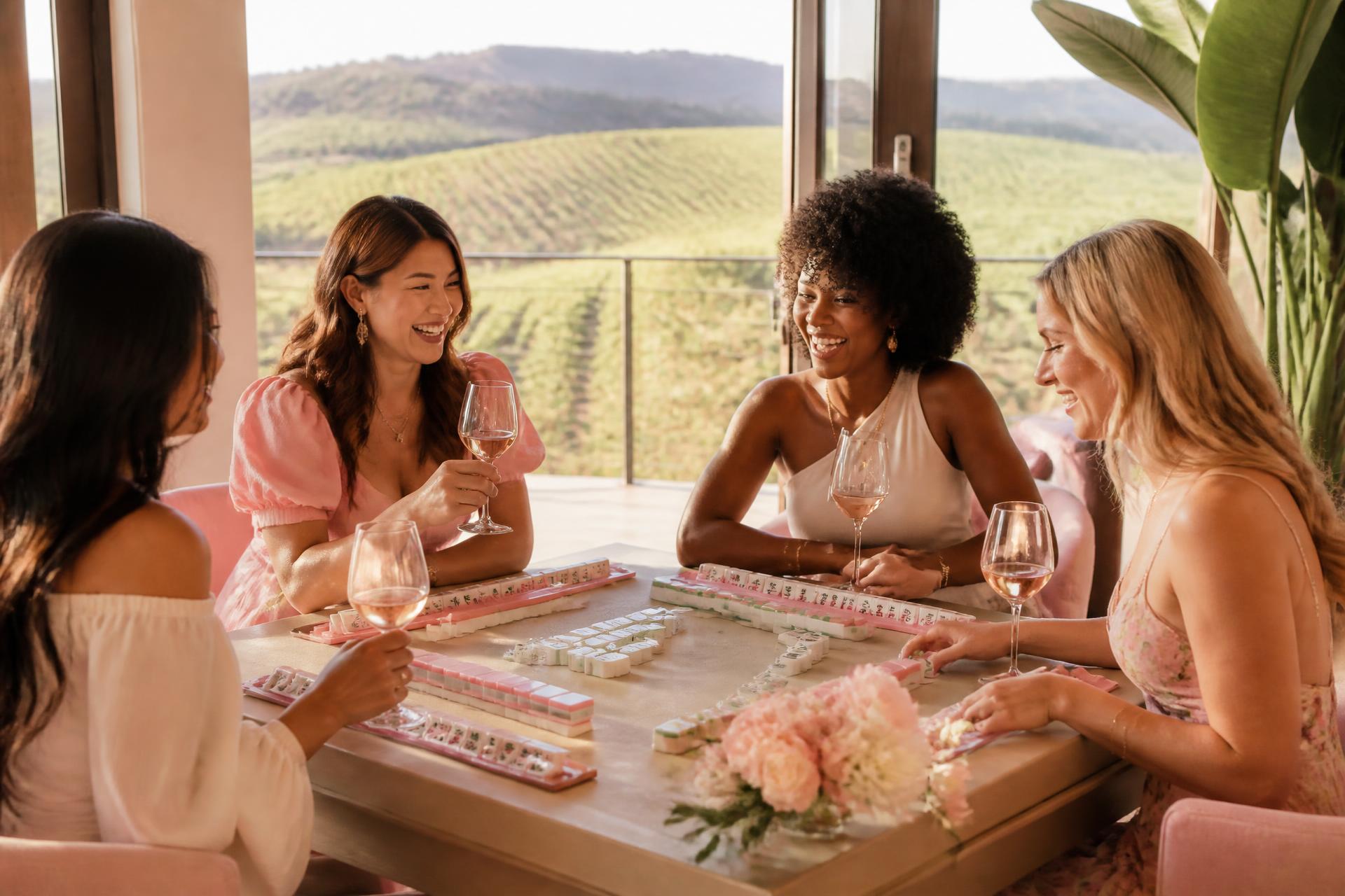Women gathered around a mahjong table with wine at a winery